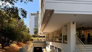 A building entrance with a covered walkway leading to a staircase. - Flat Sudoeste Ed. Leonardo (Brasília)