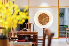 Un coin repas avec une table en bois, des chaises et un élément décoratif mural.