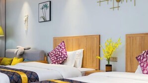 Habitación de hotel con dos camas, cabecero de madera, mesita de noche, lámpara, una obra de arte colgada en la pared y una planta en maceta.