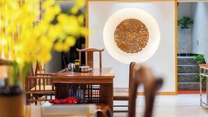 Una mesa de comedor de madera tradicional con sillas, un jarrón de flores amarillas y un adorno en la pared.