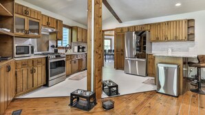 A spacious kitchen with wooden cabinets, stainless steel appliances, and a large window. - RiverFront Retreat/Fenced/LOVEDogsStayForFree/KingBeds/Sauna+SteamShower (Ellijay)
