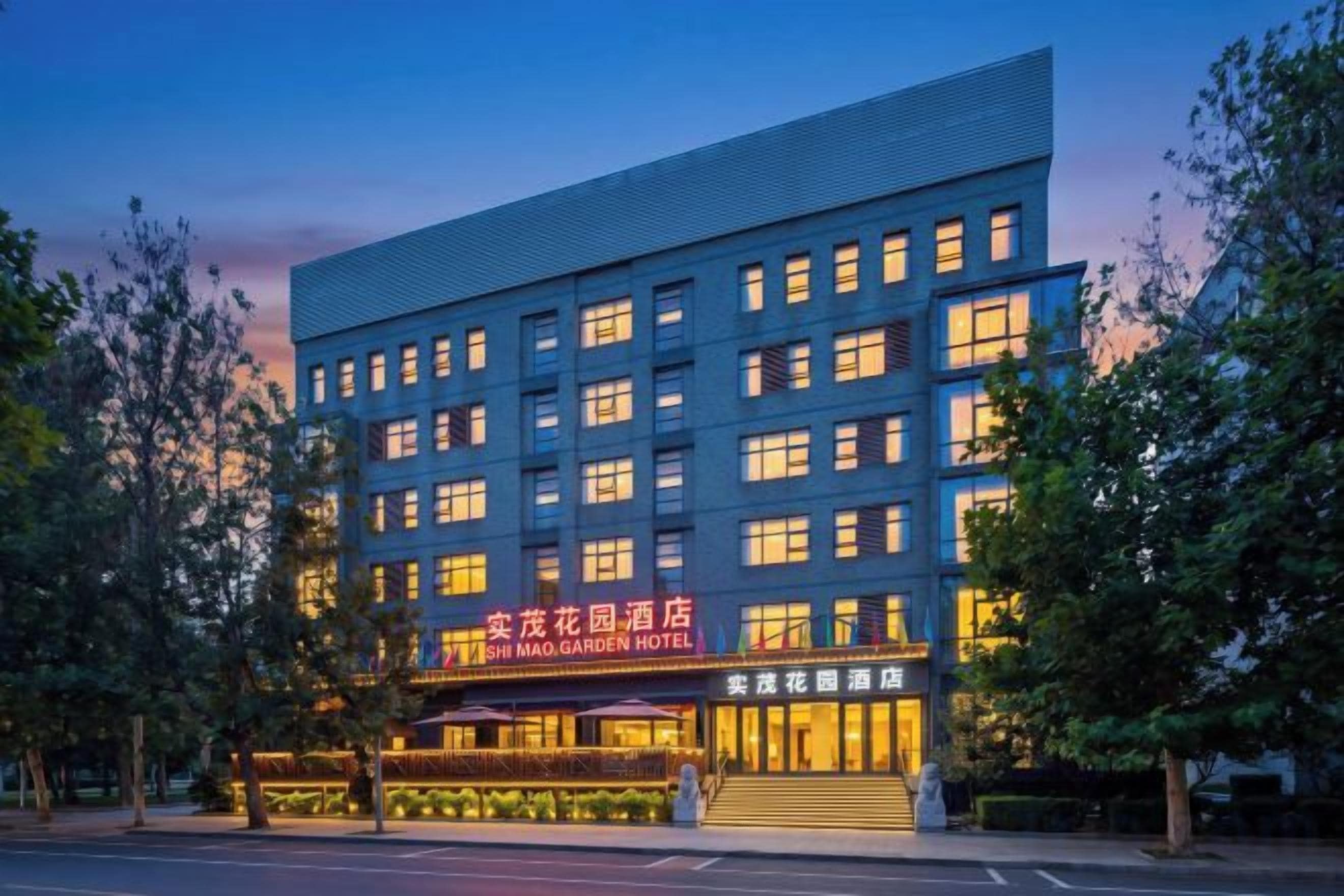A multi-story hotel with a modern facade, multiple windows, and a well-lit entrance.
