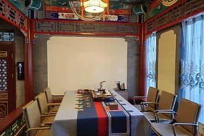 A conference room with a long table, chairs, and a projector screen. - Shi Mao Garden Hotel (Beijing)