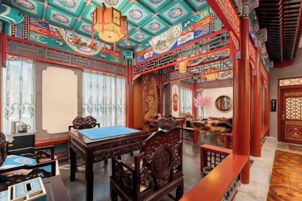 A traditional room with a wooden table, chairs, and a decorative ceiling.