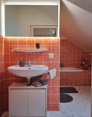 Een haardroger, handdoeken, zeep, toiletpapier