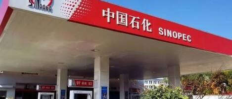 A gas station with multiple fuel pumps and a clear sky.