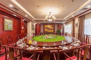 A conference room with a round table, chairs, and a chandelier. - Kaiyuan Hot Spring Resort (Dezhou)