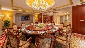 A conference room with a round table, chairs, a chandelier, and a television. - Kaiyuan Hot Spring Resort (Dezhou)