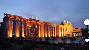 A large, illuminated building with a symmetrical facade, featuring multiple columns and a central entrance. - Kaiyuan Hot Spring Resort (Dezhou)