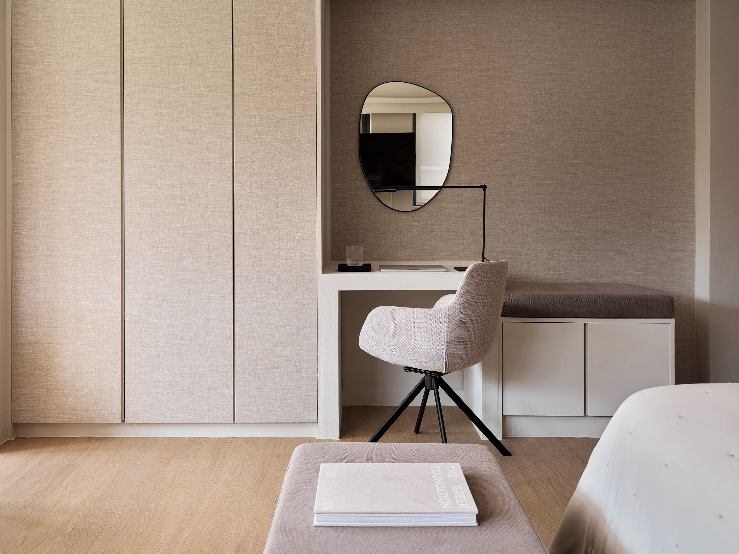 A minimalist bedroom with a bed, a desk, and a chair.