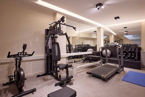 A home gym with a treadmill, elliptical, weight bench, and various exercise equipment.