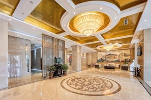 A spacious lobby with a grand chandelier, a central decorative floor pattern, and a reception area with a desk and chairs. - Wanshou Palace Hotel (Lanzhou)
