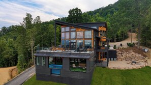 A modern two-story house with large windows, a pool, and a deck. - Skyline Sanctuary by Avantstay Indoor Pool, Game Room, Firepit, Mountain Views, Luxe Design (Sevierville)