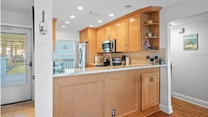 Una cocina moderna con armarios de madera, electrodomésticos de acero inoxidable y una isla grande.