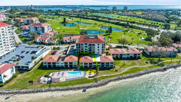 Un resort con varias edificaciones, un campo de golf y una playa.