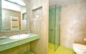 Een badkamer met een wit wastafelmeubel, spiegel en een douchecabine van glas.