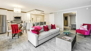 A modern living room with a grey sofa, red and white cushions, a coffee table, and a red chair. - Marco Island Condo w/ Balcony + Water Views! (Marco Island)