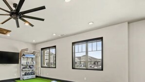 A room with a ceiling fan, a window with a view, a shelf with items, and a green mat on the floor. - My Peaceful Place (Burleson)