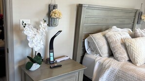 A bedroom with a bed, nightstand, and wall-mounted decor. - My Peaceful Place (Burleson)