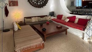Una sala de estar moderna con un sofá, una mesita de centro y un elemento decorativo en la pared.