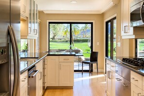 A modern kitchen with a view of a landscaped garden. - NEW LISTING - PALM SPRINGS INDIAN CANYONS LUXURY ESTATE WITH GOLF COURSE VIEWS (Palm Springs)