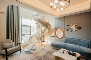 Un interior moderno con una escalera de caracol, un sofá azul y una alfombra estampada.