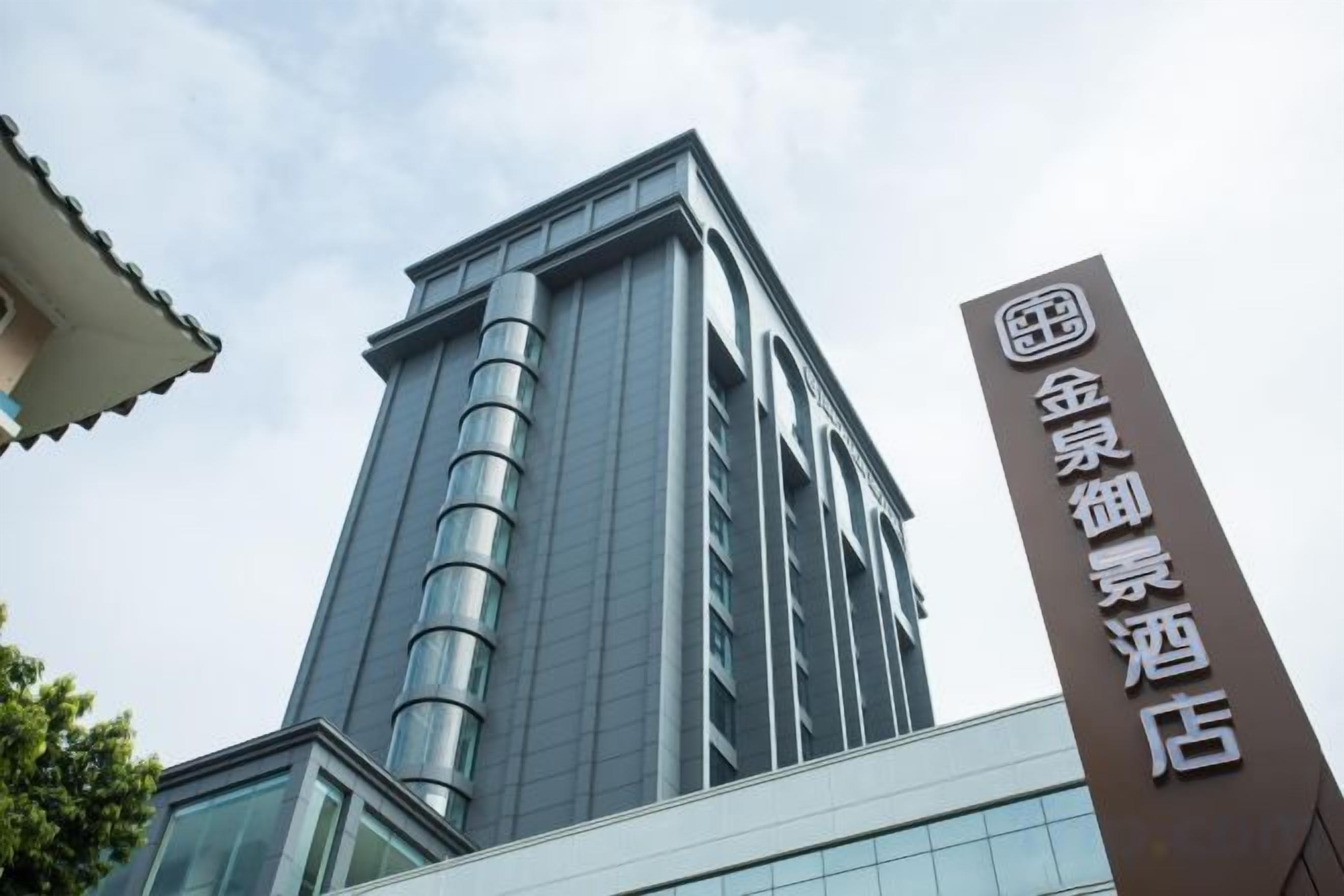 A tall building with a modern design, featuring a prominent vertical sign with text.