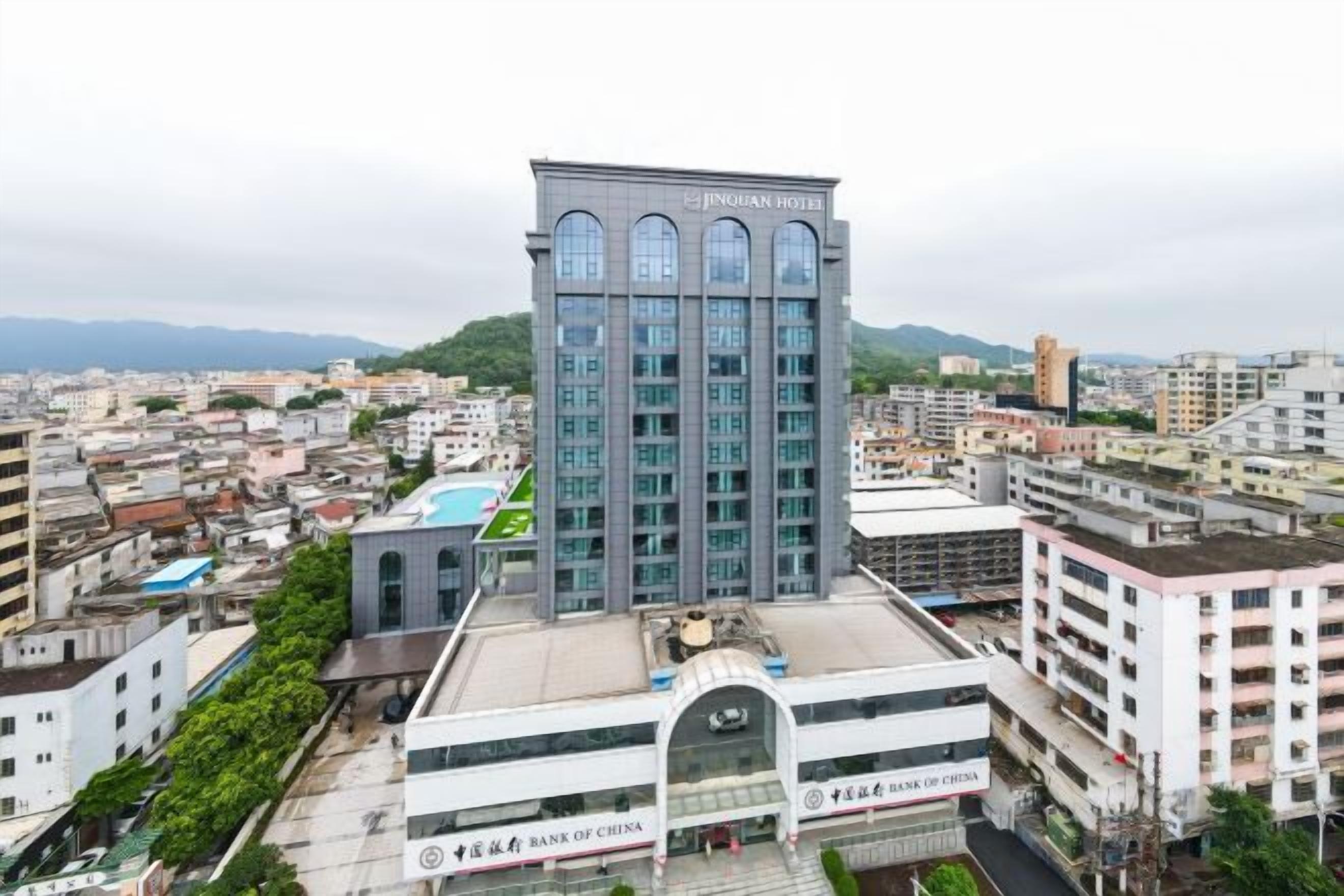 A multi-story hotel with a modern design, featuring a prominent entrance and a rooftop area.