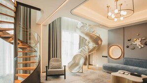 A modern interior with a spiral staircase, a lounge area, and a unique ceiling design. - Jinquan Yujing Hotel (Enping)