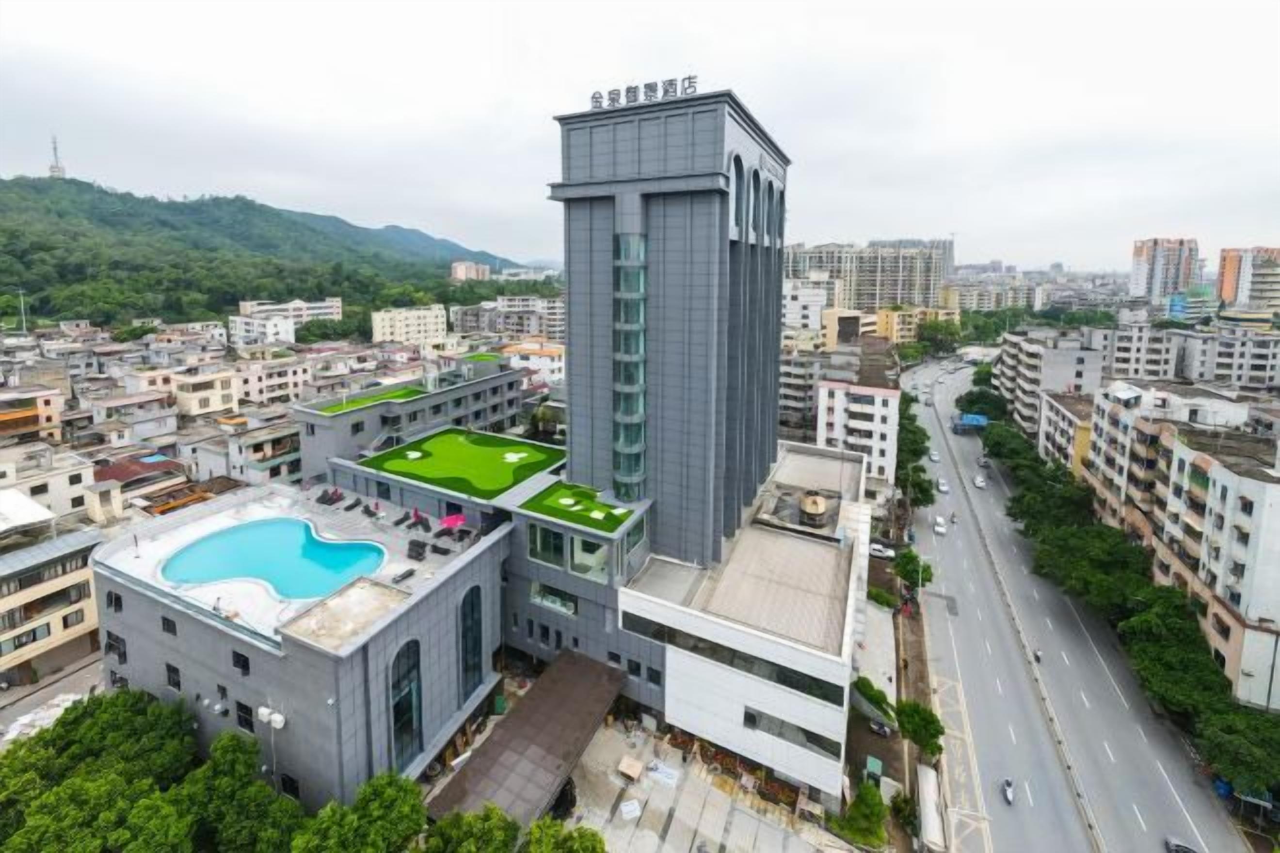 Un edifici modern amb una piscina al terrat i una torre alta.