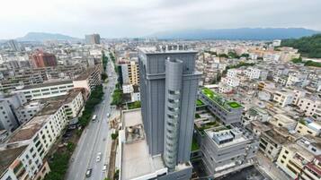 Un paisaje urbano con modernos rascacielos, una avenida amplia y montañas a lo lejos.