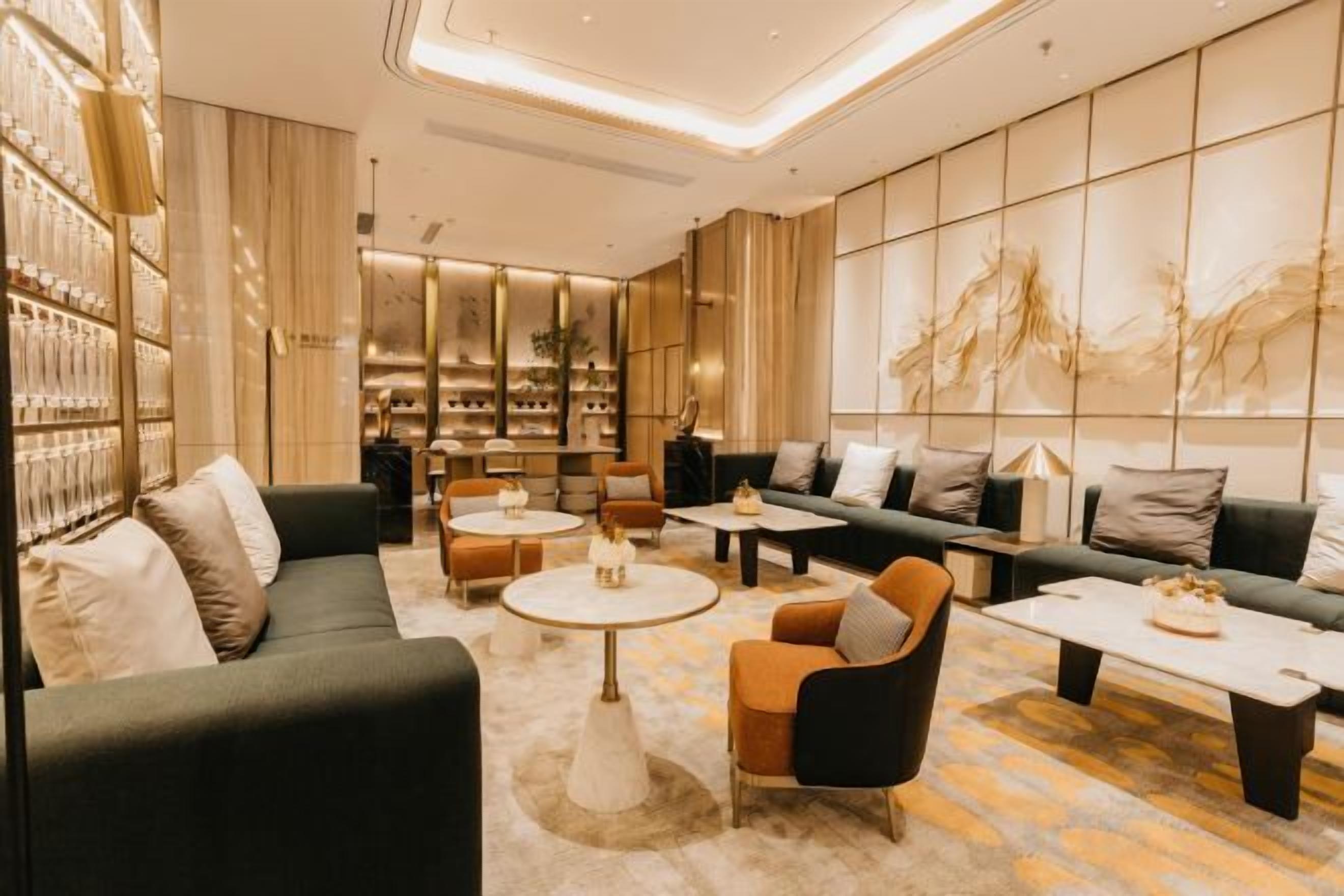 Un salón moderno con sofás, sillones y mesas de centro, dispuesto para reuniones.