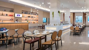 En modern hotellobby med en receptionsdisk, en sittgrupp och en bar.
