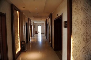 A long, narrow hotel corridor with doors on both sides, leading to rooms. - You Yi Feng Hotel (Habahe)