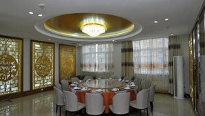 Un tavolo rotondo da pranzo con sedie, un lampadario e pannelli decorativi.