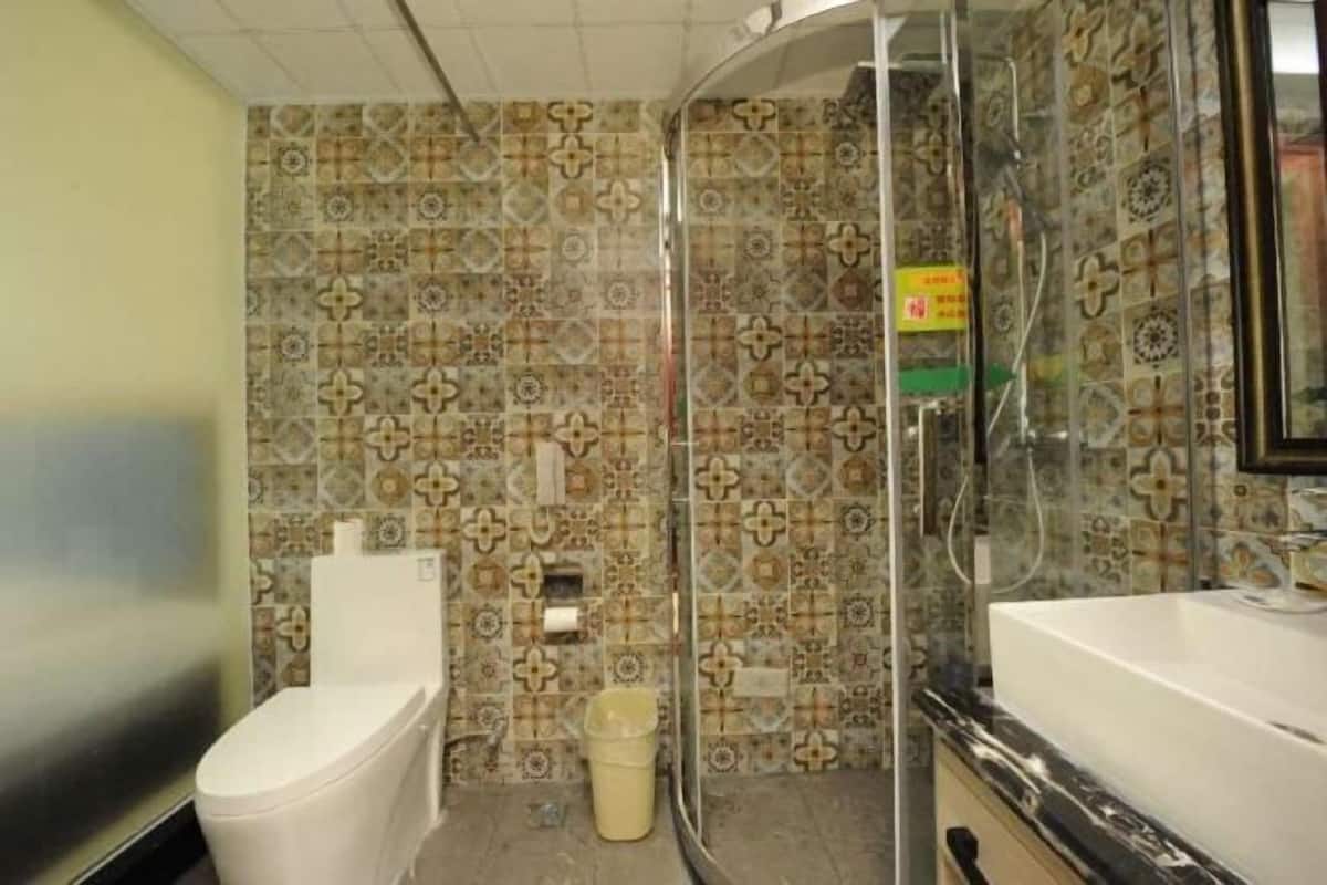 A bathroom with patterned tiles, a toilet, a bidet, and a sink.