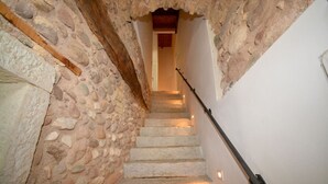 Un escalier en pierre mène à une porte en bois située en haut.