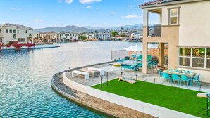 A modern building with a pool, outdoor seating, and a view of the mountains. - Specials Barbie themed, Lakefront, games+pool (Indio)