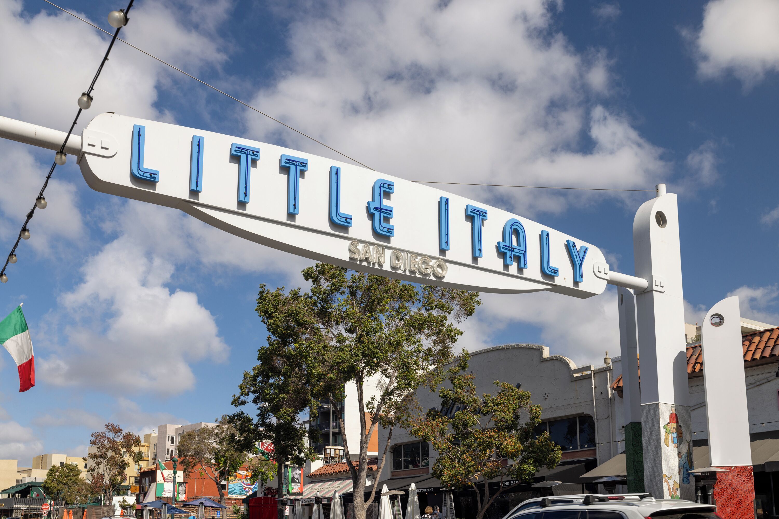 A sign for "Little Italy" with a clear view of the surrounding buildings and street.