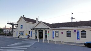 A train station with a pedestrian crossing and a car parked nearby. - Newly Renovated Gem: 15 mins train ride to Paris (Sarcelles)