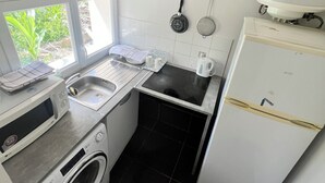 A compact kitchen with a washing machine, a microwave, a sink, and a refrigerator. - Newly Renovated Gem: 15 mins train ride to Paris (Sarcelles)