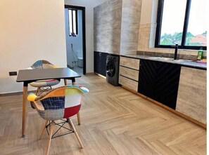 Enjoy a meal in the kitchen with a view, featuring a dishwasher and a table with a chair.