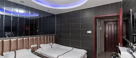 Une chambre d’hôtel avec deux lits, un design moderne au niveau du plafond, un grand miroir et une machine à café.