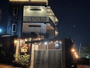 DLK property features a modern two-story building with a flat roof, large windows, and a balcony.
