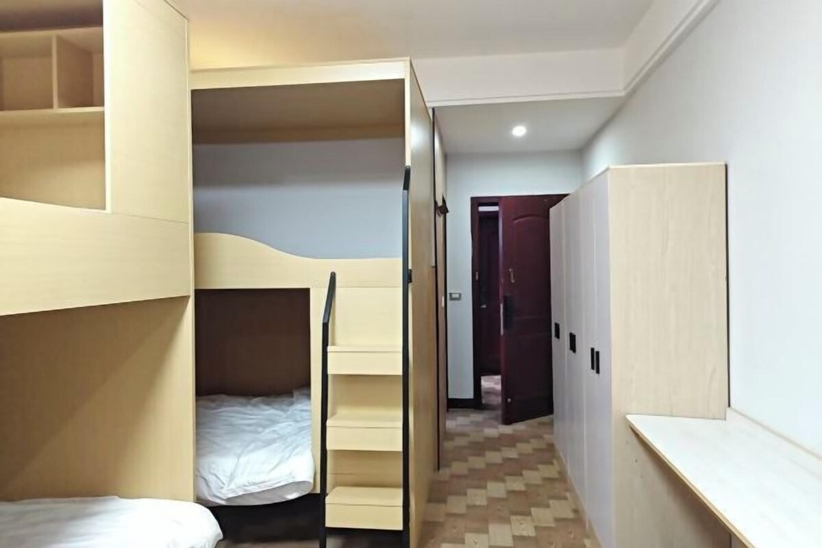 Quarto com beliches, guarda-roupa e porta que dá para outro espaço.