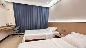 A hotel room with two beds, a desk, a chair, and a large window with curtains. - Changning Yanyi Hotel (Changning)