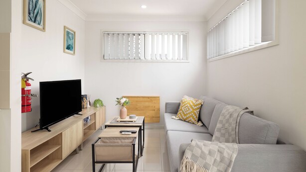 A modern living room with a flat-screen TV, a sofa, a coffee table, and a small side table. - 1 Bdr Apt w/ AC & Kitchen | Parking | 135F1 (Rocklea)