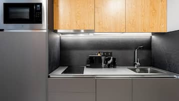 A modern kitchen with a built-in microwave, a coffee maker, and a sink.