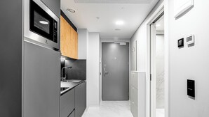 Una cocina moderna con microondas integrado, electrodomésticos de acero inoxidable y armarios de madera.