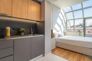 A modern kitchen with grey cabinets, a black countertop, and a window overlooking a cityscape. - City Pop 2Night Prague - Self check-in (Prague)